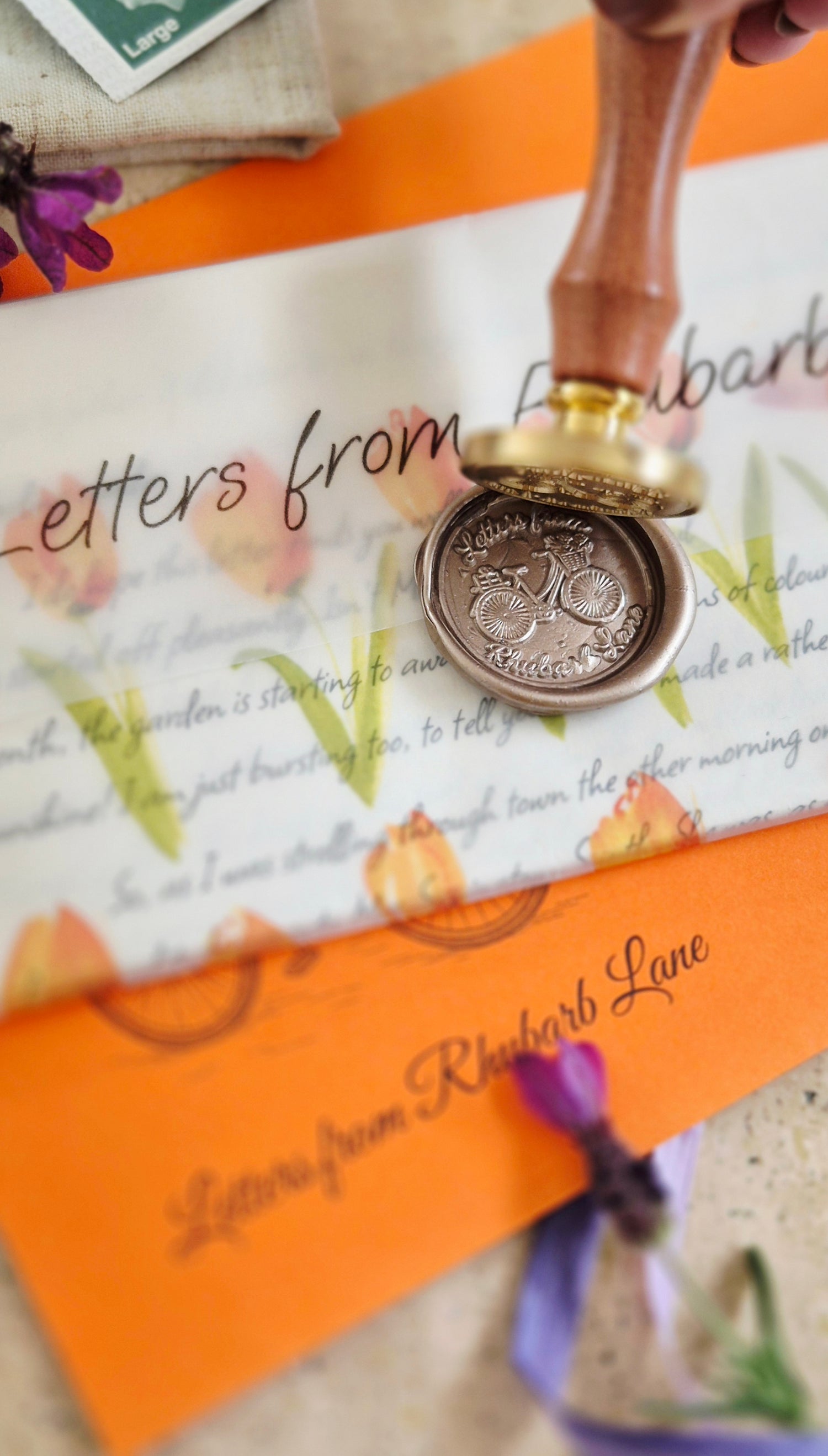 Decorative wax seal stamp on a letter with 'Letters from Rhiannon Lane' text.